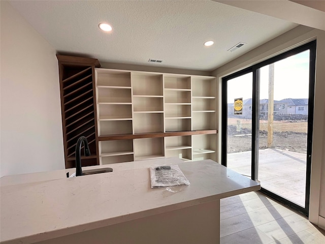 unfurnished office with sink and a textured ceiling