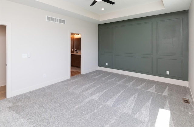 18016 Tanglewood Dr, Clive, IA 50325 - unfurnished bedroom with carpet, a tray ceiling, a ceiling fan, ensuite bath, and recessed lighting