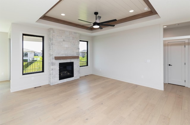 18016 Tanglewood Dr, Clive, IA 50325 - unfurnished living room with a tray ceiling, ceiling fan, light wood-style floors, a fireplace, and recessed lighting