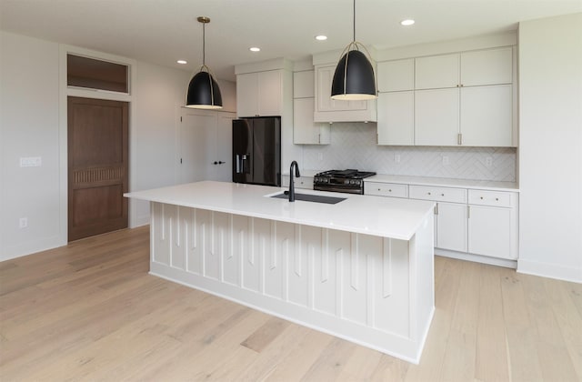 18016 Tanglewood Dr, Clive, IA 50325 - kitchen featuring black fridge, backsplash, light wood-type flooring, recessed lighting, and white cabinetry