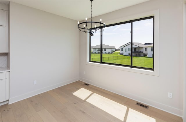 18016 Tanglewood Dr, Clive, IA 50325 - unfurnished dining area featuring plenty of natural light, a chandelier, and light wood-type flooring