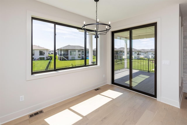 18016 Tanglewood Dr, Clive, IA 50325 - unfurnished dining area featuring healthy amount of natural light, a chandelier, wood finished floors, and a residential view