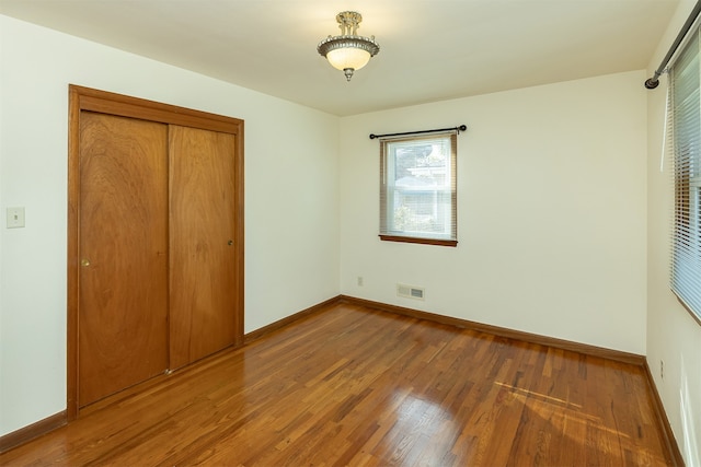 unfurnished bedroom with a closet and hardwood / wood-style flooring