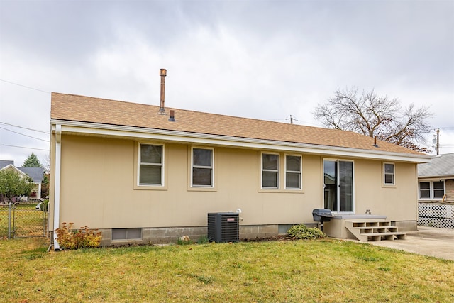 rear view of house with a lawn and central AC unit