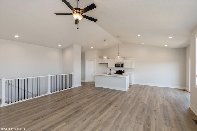 unfurnished living room featuring ceiling fan, light wood-type flooring, sink, and vaulted ceiling