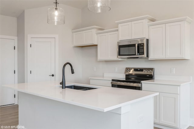 kitchen with white cabinetry, sink, an island with sink, pendant lighting, and appliances with stainless steel finishes