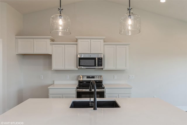 kitchen featuring white cabinets, decorative light fixtures, stainless steel appliances, and lofted ceiling