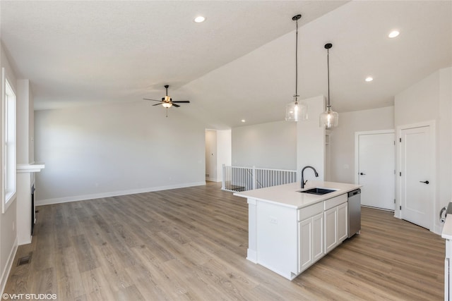 kitchen with light hardwood / wood-style flooring, a kitchen island with sink, lofted ceiling, and sink