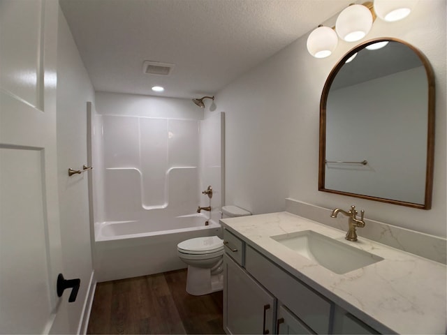 full bathroom with toilet, vanity, wood-type flooring, and washtub / shower combination