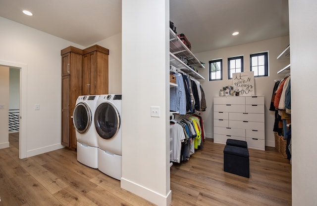 washroom featuring cabinets, light hardwood / wood-style floors, and independent washer and dryer