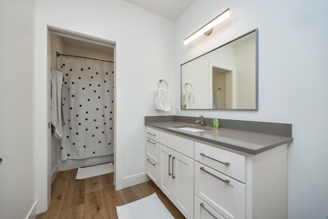 bathroom featuring walk in shower, vanity, and hardwood / wood-style floors