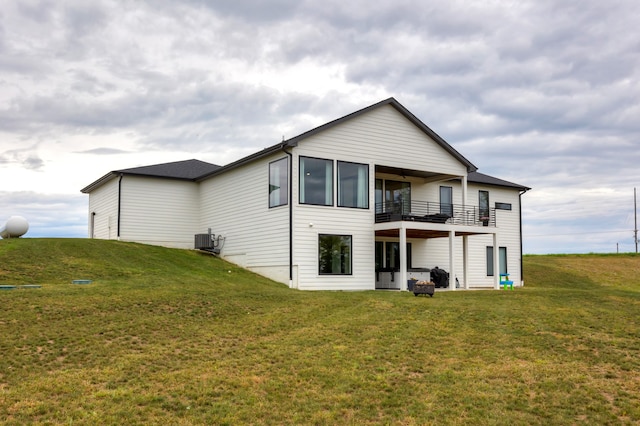 back of house with a lawn, a balcony, and central AC unit