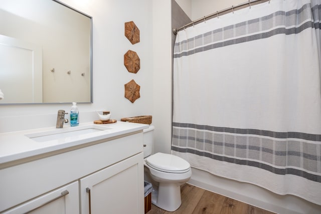 full bathroom with shower / bathtub combination with curtain, wood-type flooring, vanity, and toilet