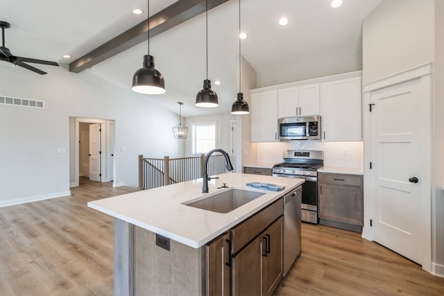 kitchen with ceiling fan, sink, white cabinetry, stainless steel appliances, and light wood-type flooring