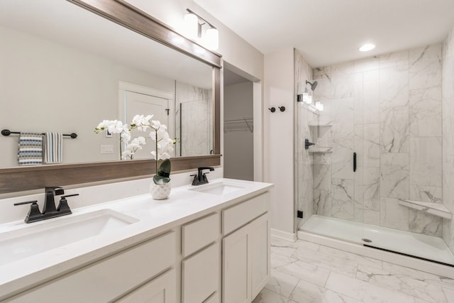 bathroom featuring a shower with door and vanity