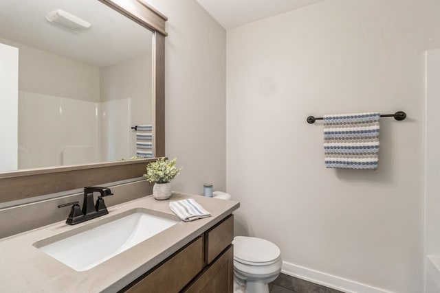 bathroom with walk in shower, vanity, toilet, and tile patterned floors