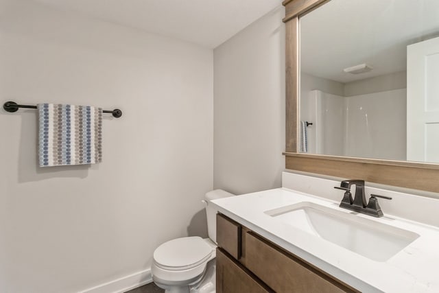 bathroom featuring walk in shower, vanity, and toilet