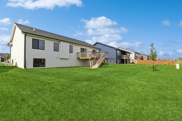 rear view of house with a deck and a lawn