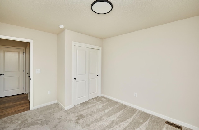 unfurnished bedroom with a closet and carpet flooring