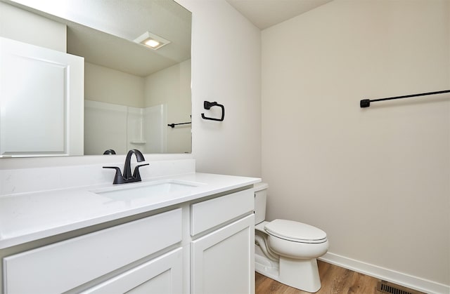 bathroom featuring wood-type flooring, toilet, and vanity