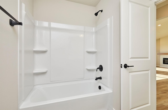 bathroom featuring hardwood / wood-style flooring and bathing tub / shower combination