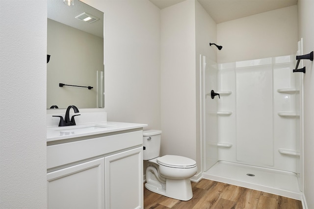 bathroom featuring vanity, toilet, a shower, and hardwood / wood-style floors