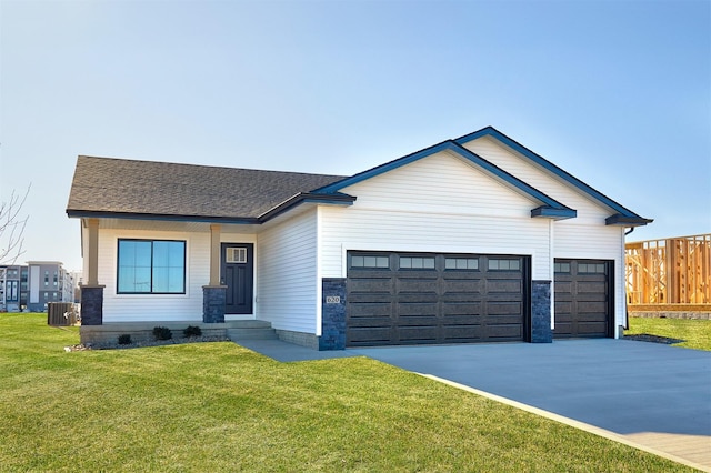 view of front facade featuring central air condition unit, a garage, and a front lawn