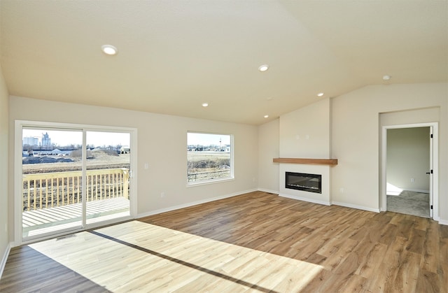 unfurnished living room with hardwood / wood-style floors and lofted ceiling