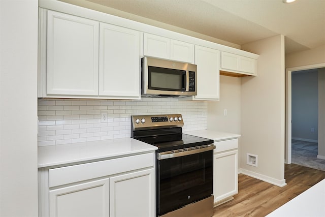 kitchen featuring white cabinetry, light hardwood / wood-style flooring, appliances with stainless steel finishes, and tasteful backsplash