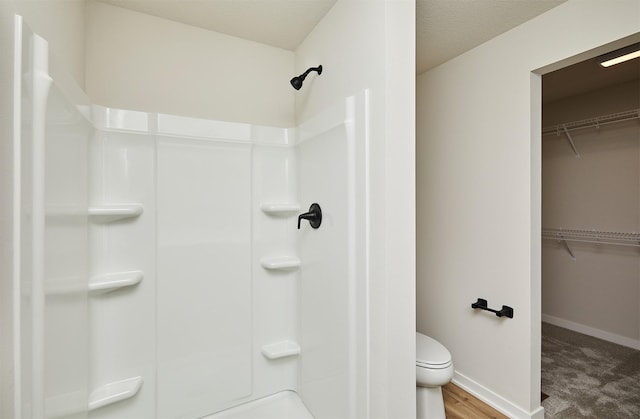 bathroom with a shower, a textured ceiling, and toilet