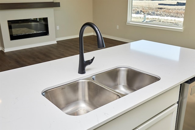 details with dark wood-type flooring, sink, white cabinets, and dishwasher