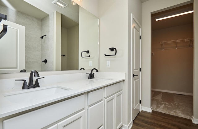 bathroom with vanity, hardwood / wood-style flooring, and tiled shower