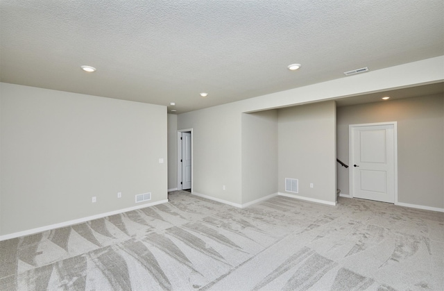 carpeted spare room with a textured ceiling