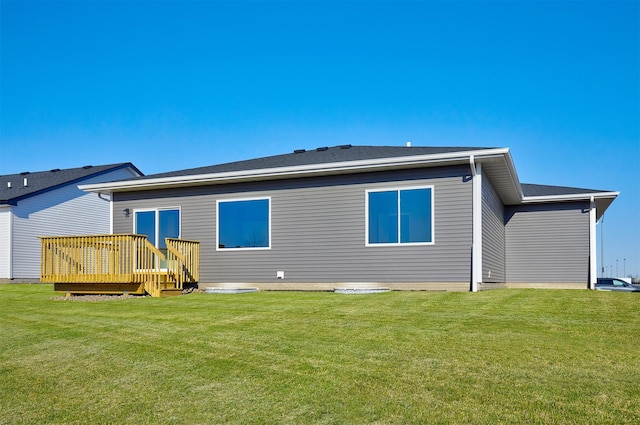 rear view of property with a lawn and a wooden deck