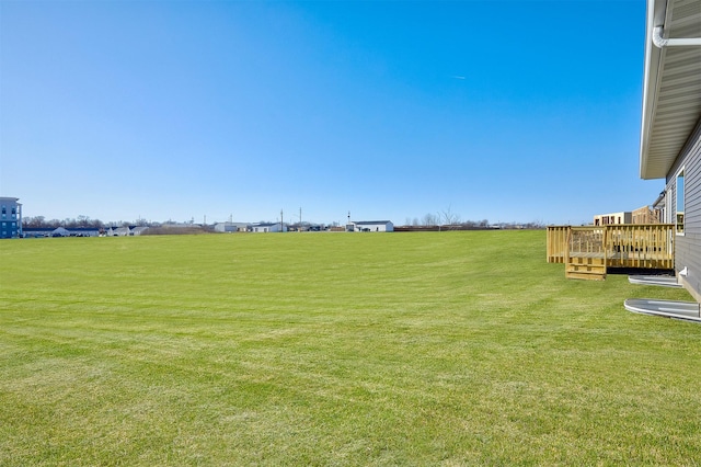 view of yard featuring a wooden deck and a rural view