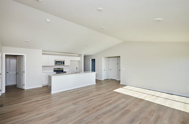 kitchen with sink, an island with sink, white cabinetry, light wood-type flooring, and appliances with stainless steel finishes