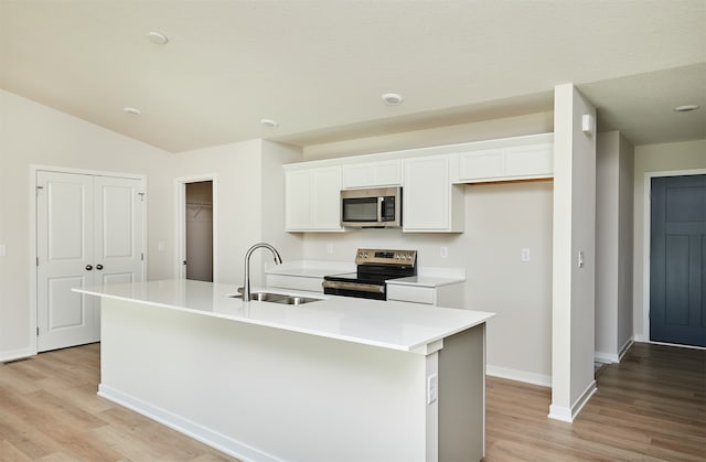 kitchen with white cabinetry, appliances with stainless steel finishes, sink, and an island with sink