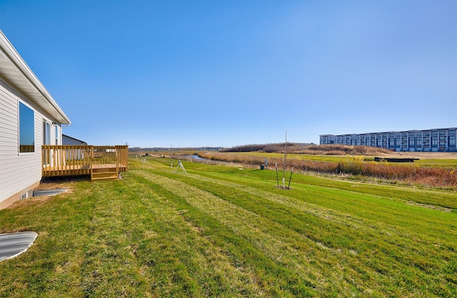 view of yard featuring a wooden deck and a rural view