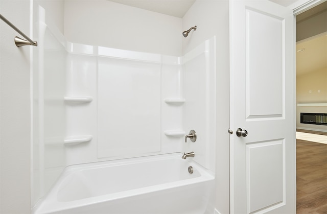 bathroom with wood-type flooring and shower / tub combination