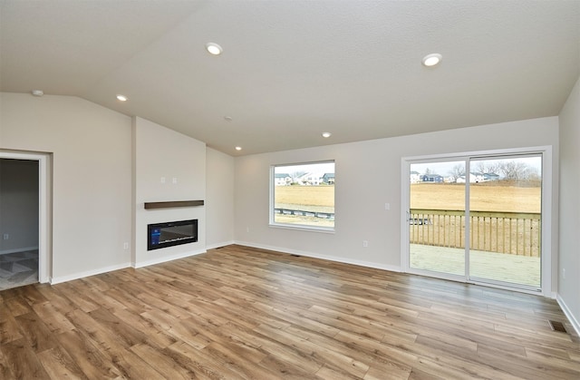 unfurnished living room with light hardwood / wood-style flooring and vaulted ceiling