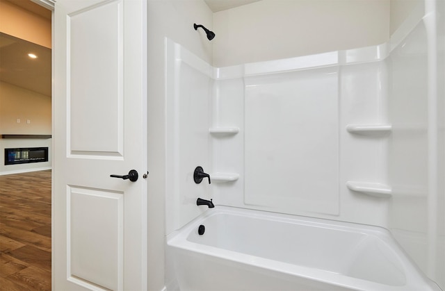 bathroom featuring hardwood / wood-style floors and  shower combination