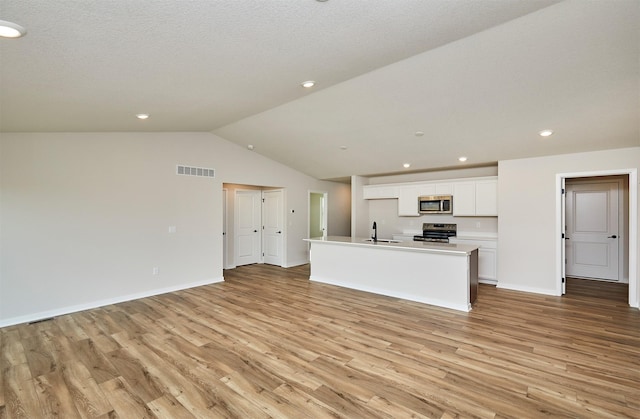 kitchen featuring a center island with sink, white cabinets, light wood-type flooring, and stainless steel appliances