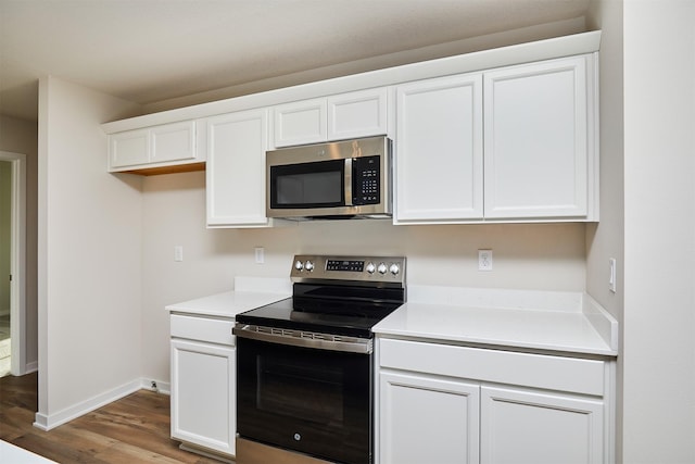 kitchen featuring white cabinets, stainless steel appliances, and wood-type flooring