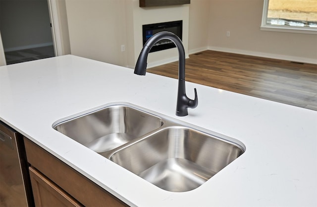 room details featuring hardwood / wood-style floors, stainless steel dishwasher, and sink