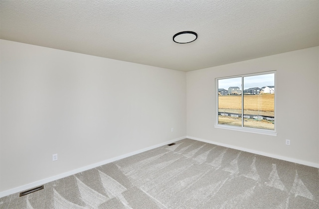 unfurnished room featuring carpet flooring and a textured ceiling