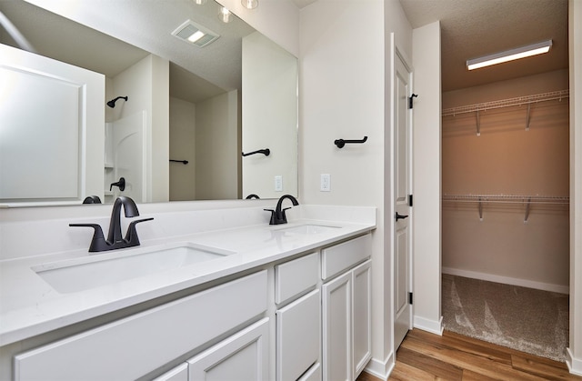 bathroom with hardwood / wood-style floors, vanity, and walk in shower