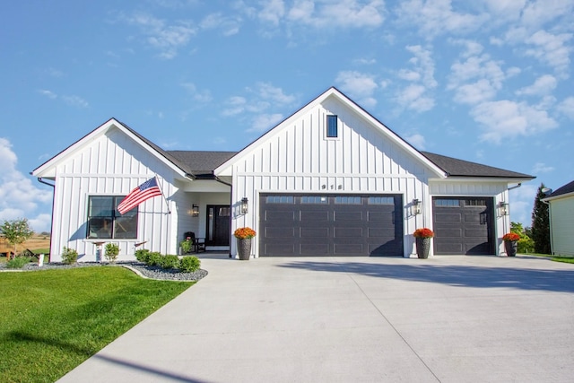 modern farmhouse style home with a front yard and a garage