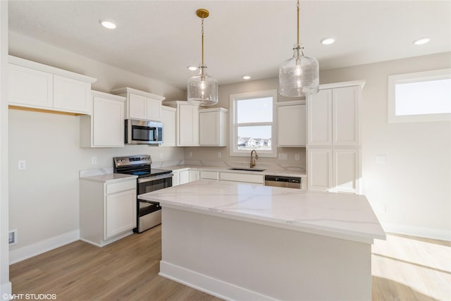 kitchen with a center island, white cabinetry, stainless steel appliances, and a wealth of natural light