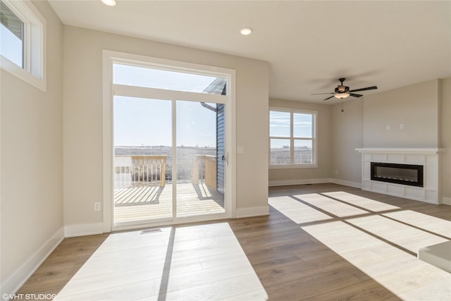 unfurnished living room with hardwood / wood-style flooring and ceiling fan