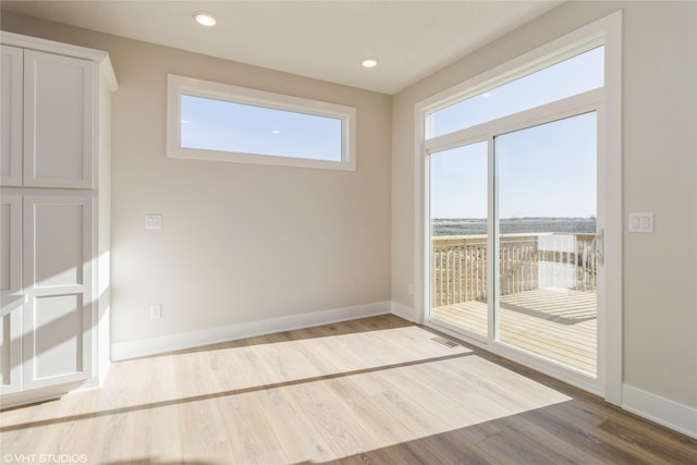 empty room with wood-type flooring and a wealth of natural light